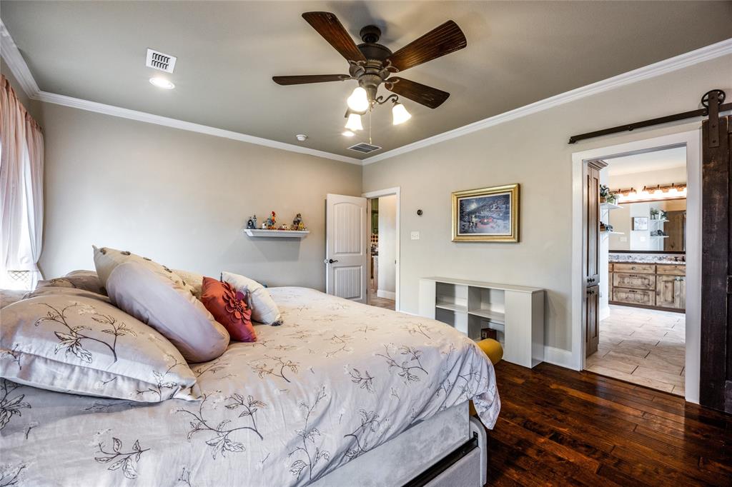 1462 Durham Road Whitewright, TX 75491 - Photo 16 of 40 a bedroom with a large bed and a chandelier