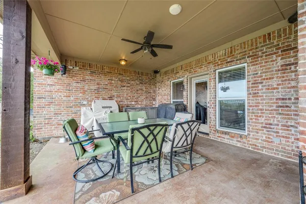 a patio with table and chairs and potted plants