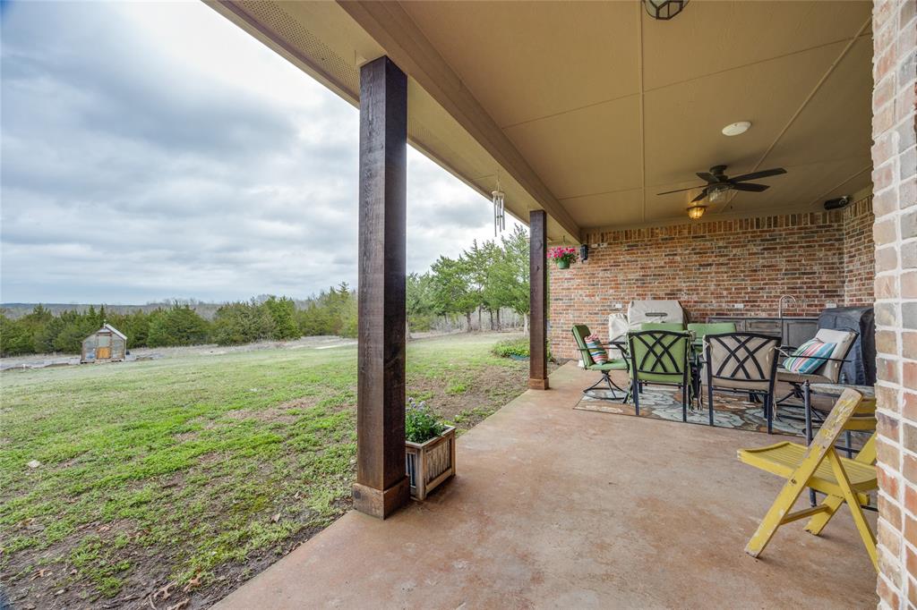 1462 Durham Road Whitewright, TX 75491 - Photo 31 of 40 a view of a patio with a table chairs and a floor to ceiling window