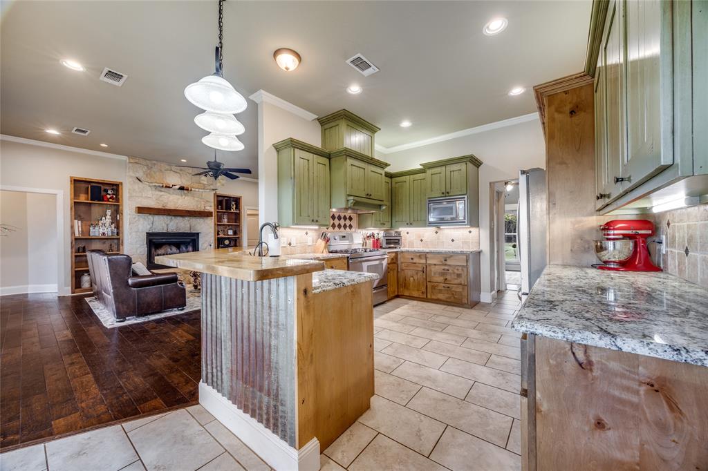 1462 Durham Road Whitewright, TX 75491 - Photo 9 of 40 a kitchen with stainless steel appliances granite countertop a sink and a refrigerator