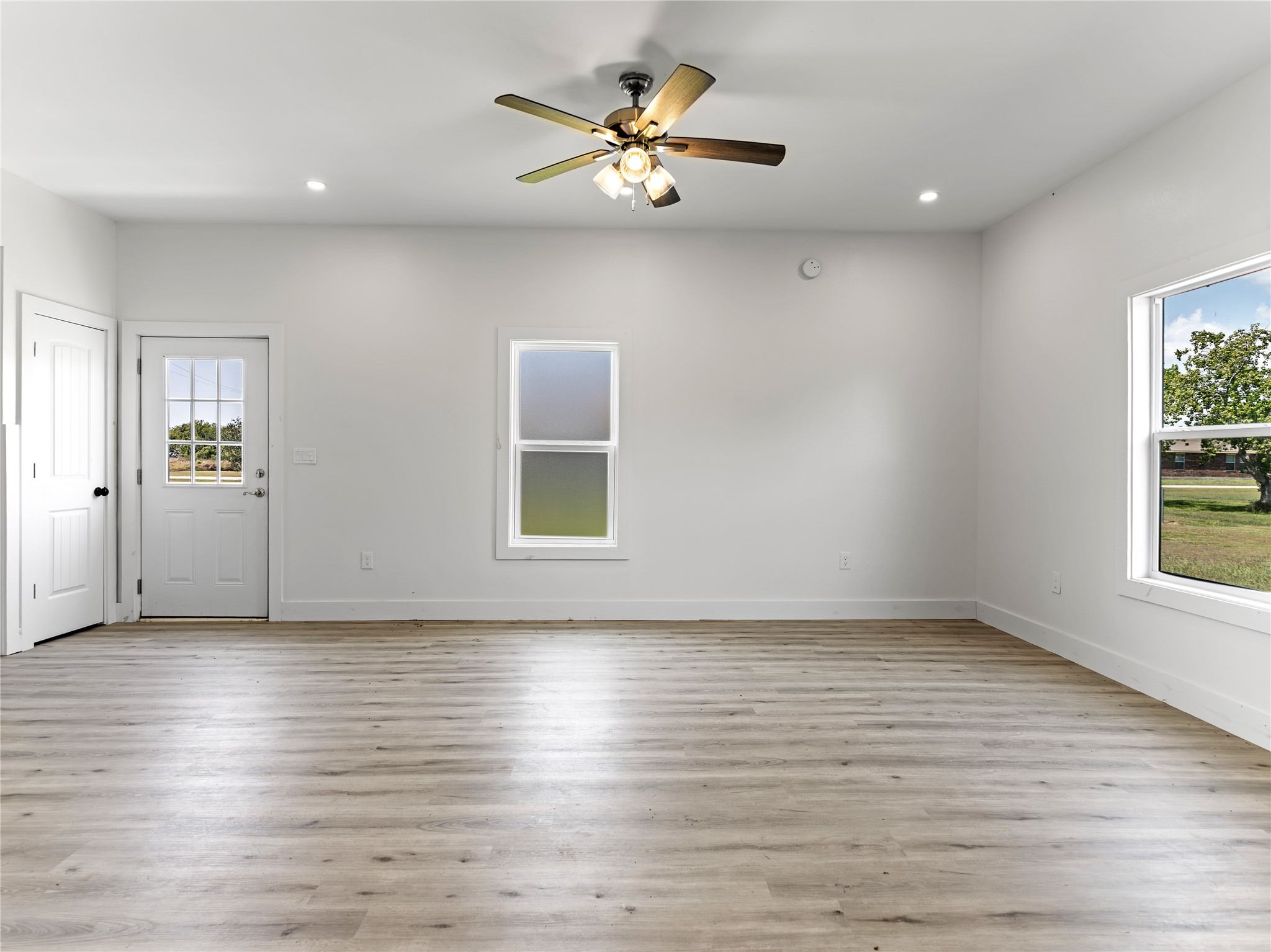 1014 Humphrey Street Palacios, TX 77465 - Photo 14 of 26 an empty room with wooden floor and windows