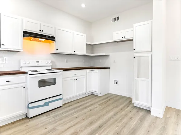 a kitchen with granite countertop a sink cabinets stainless steel appliances and a window