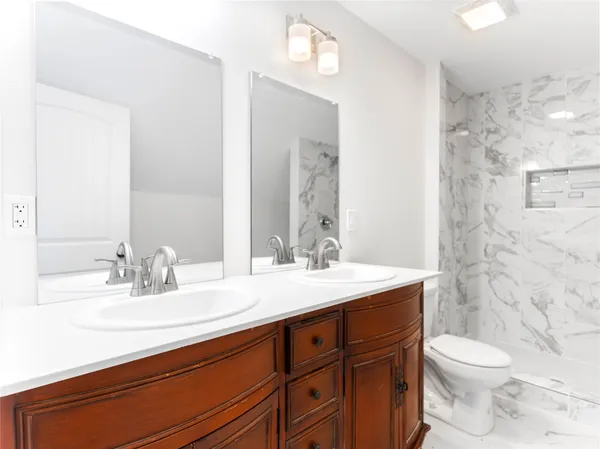 a bathroom with a sink a toilet and shower