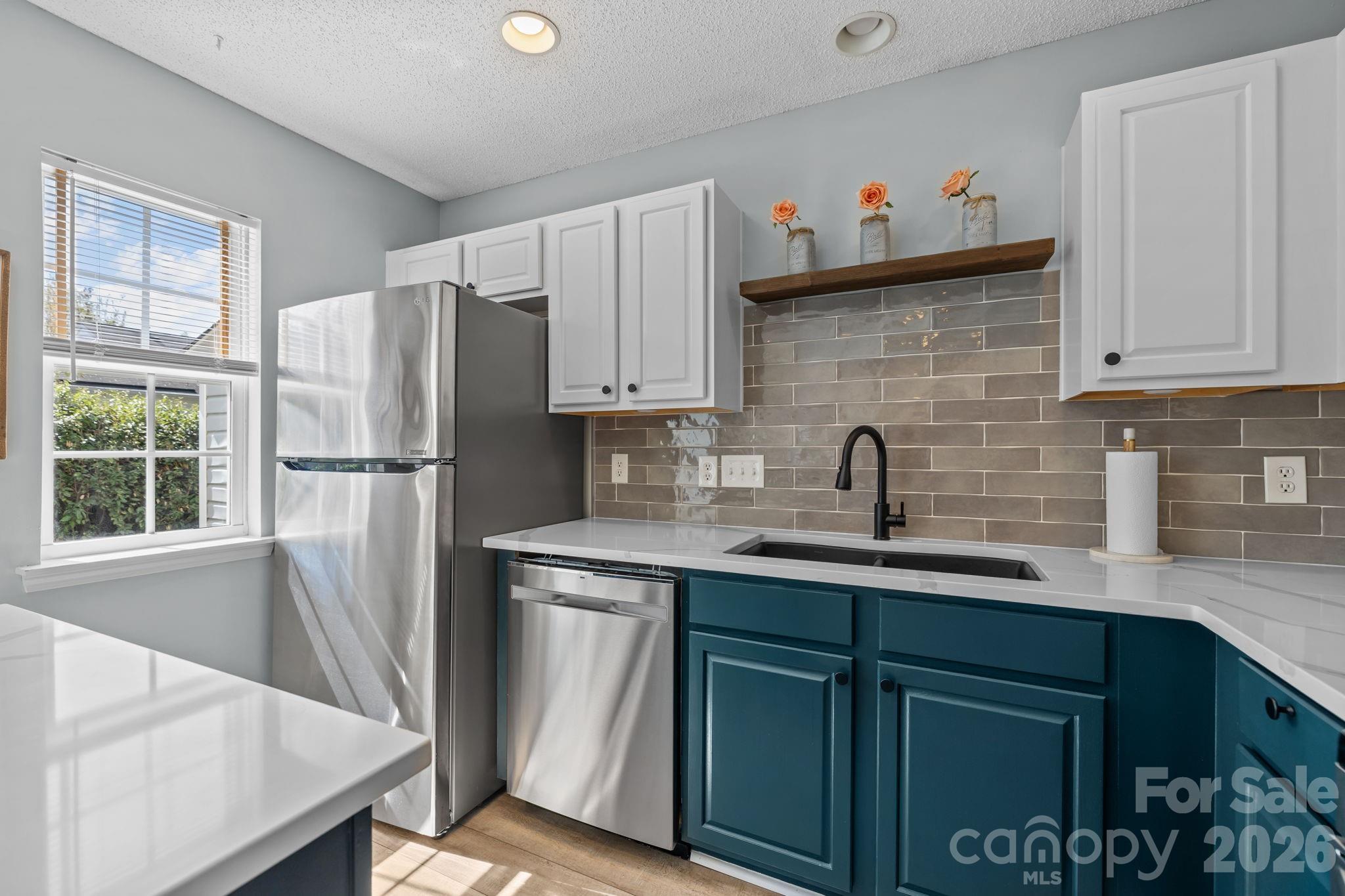 213 Butler Place Fort Mill, SC 29715 - Photo 12 of 36 a kitchen with stainless steel appliances white cabinets a sink and a refrigerator