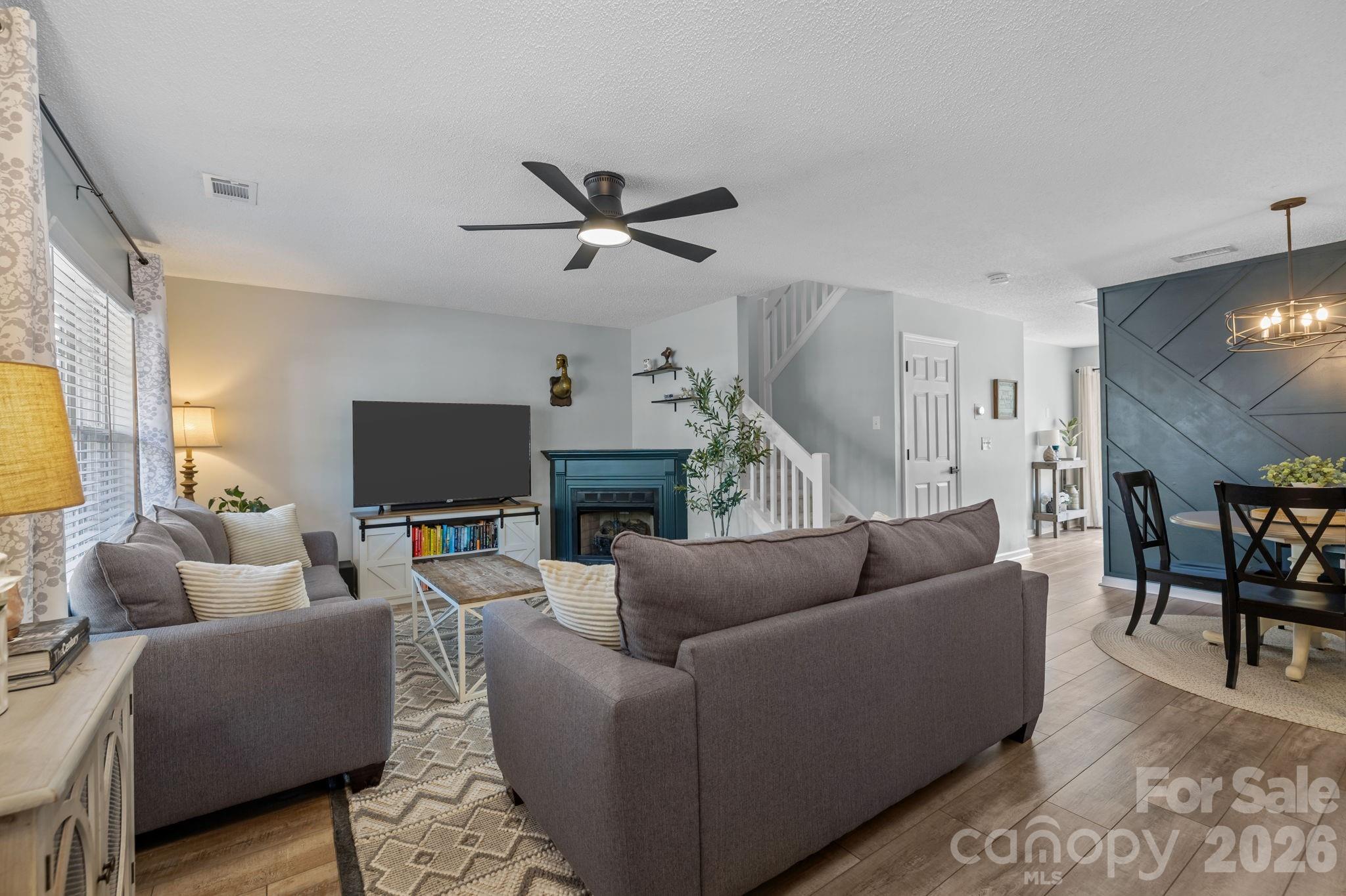 213 Butler Place Fort Mill, SC 29715 - Photo 3 of 36 a living room with furniture a ceiling fan a rug and a window