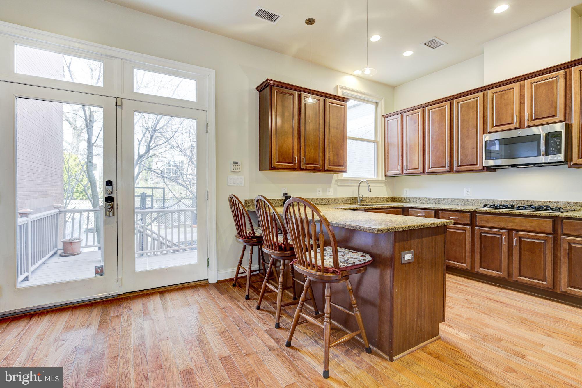 648 C Street Northeast Washington, DC 20002 - Photo 6 of 22 a kitchen with stainless steel appliances granite countertop wooden floor and a window