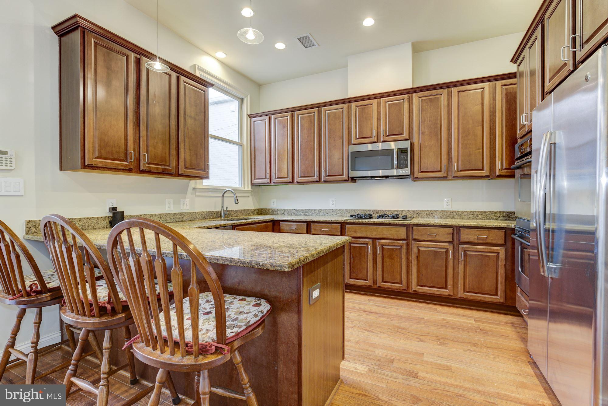 648 C Street Northeast Washington, DC 20002 - Photo 7 of 22 a kitchen with stainless steel appliances granite countertop a stove a sink and a refrigerator