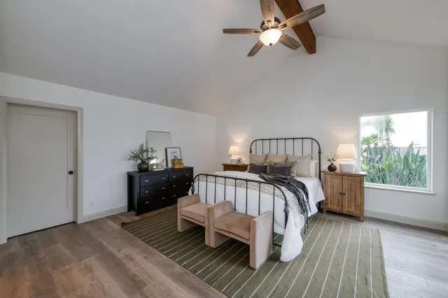 a bedroom with a bed and wooden floor