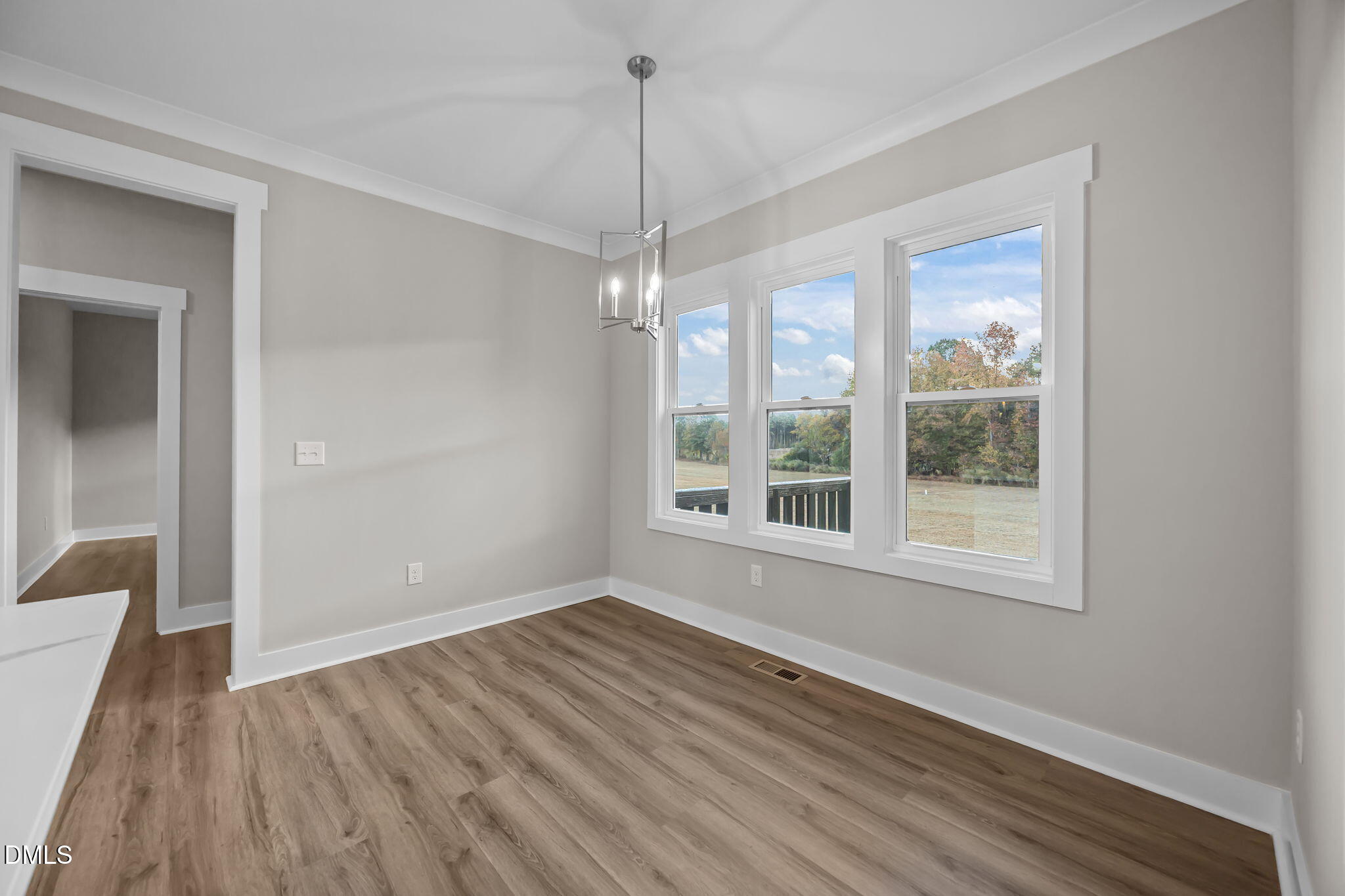 8629 Dukes Lake Road Zebulon, NC 27597 - Photo 19 of 52 a view of an empty room with wooden floor and a window