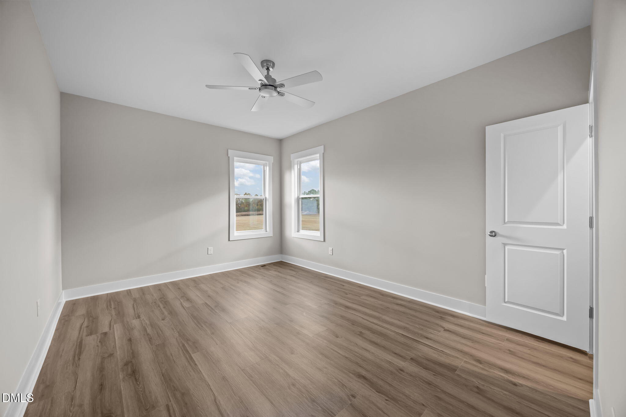 8629 Dukes Lake Road Zebulon, NC 27597 - Photo 27 of 52 a view of an empty room with wooden floor and a window