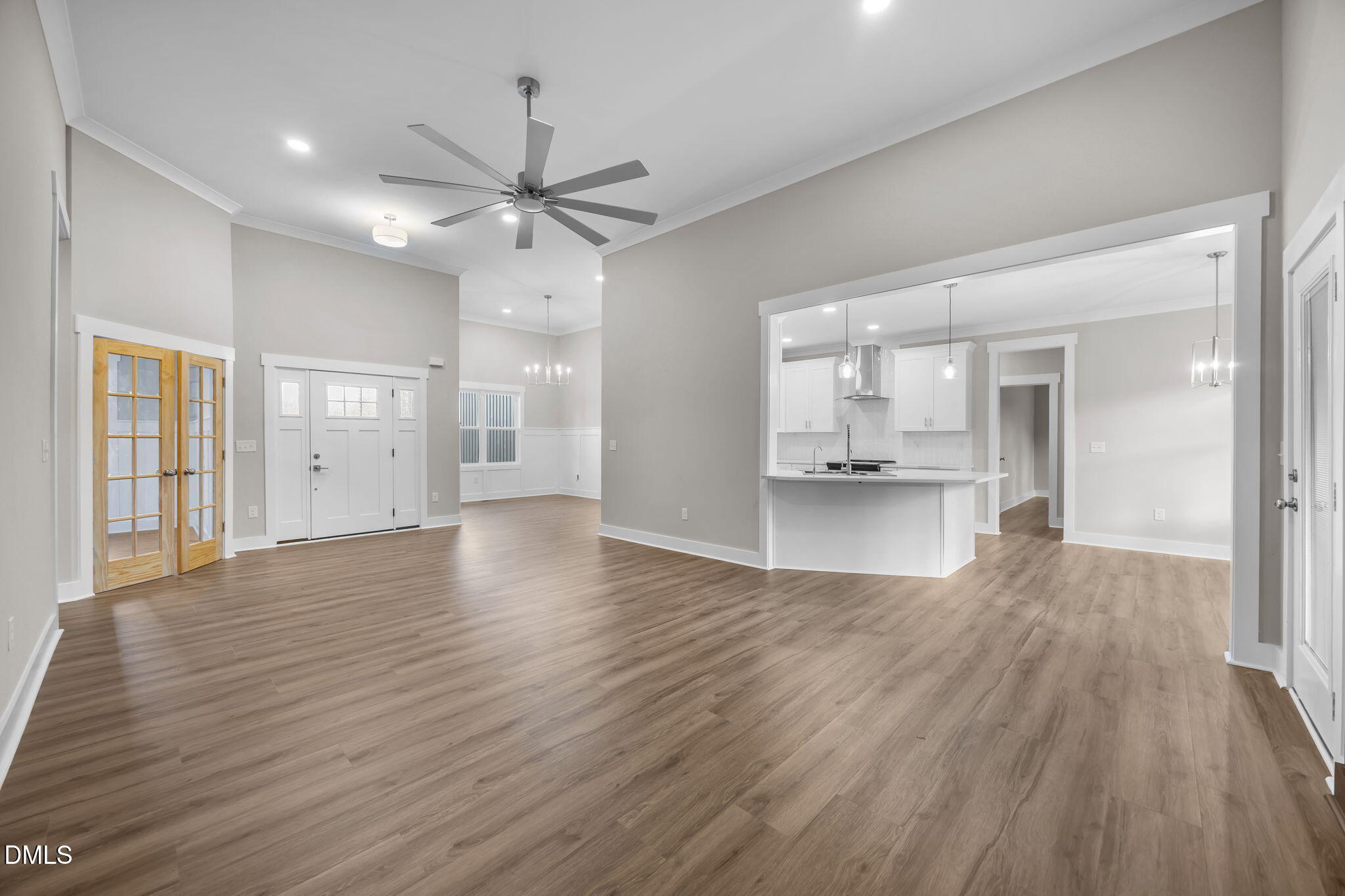 8629 Dukes Lake Road Zebulon, NC 27597 - Photo 10 of 52 a view of an empty room with wooden floor and a kitchen