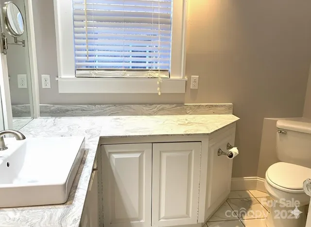 a bathroom with a granite countertop sink a toilet and a bathtub