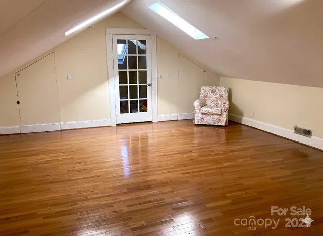 a view of an empty room with wooden floor and closet