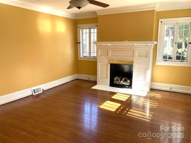 a living room with wooden floors and a fireplace