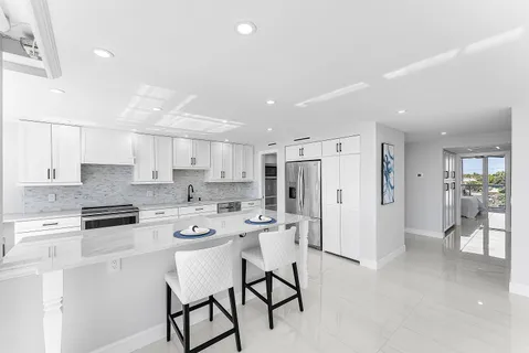 a kitchen with stainless steel appliances a refrigerator a stove a sink dishwasher and a refrigerator with wooden floor