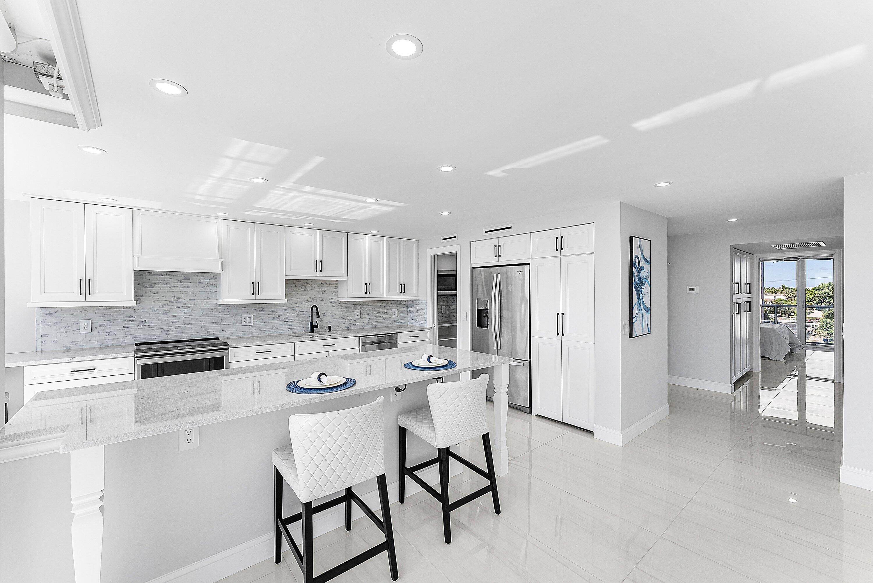 2800 South Ocean Boulevard, Unit 4E Boca Raton, FL 33432 - Photo 11 of 51 a kitchen with stainless steel appliances a refrigerator a stove a sink dishwasher and a refrigerator with wooden floor