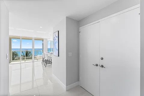 a view of a hallway with white walls and wooden floor