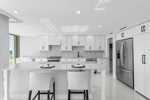 a kitchen with stainless steel appliances granite countertop a white cabinets and a refrigerator
