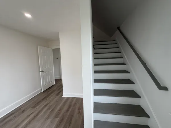 a view of a hallway with wooden floor and windows
