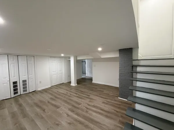 a view of an empty room with wooden floor and entryway
