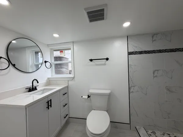 a bathroom with a toilet sink and mirror