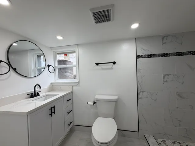 a bathroom with a toilet sink and mirror