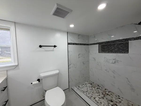 a bathroom with a toilet and a shower