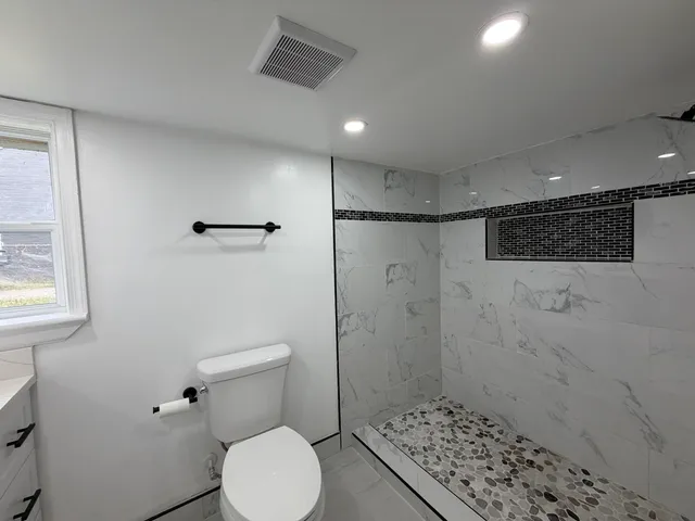 a bathroom with a toilet and a shower