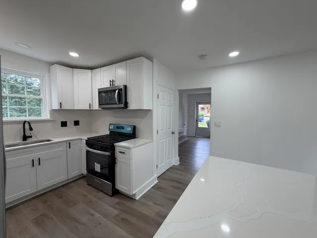 a kitchen with a sink stove and microwave