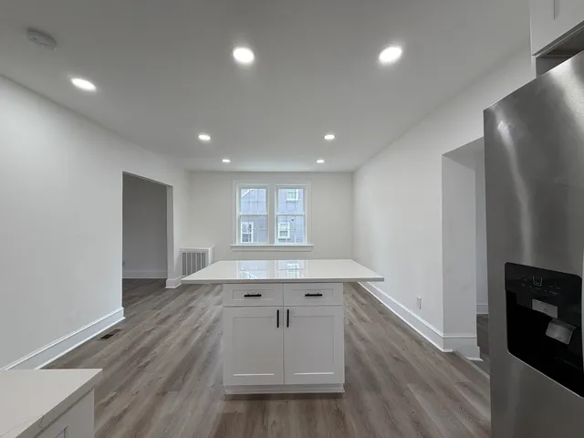 an empty room with wooden floor and fireplace