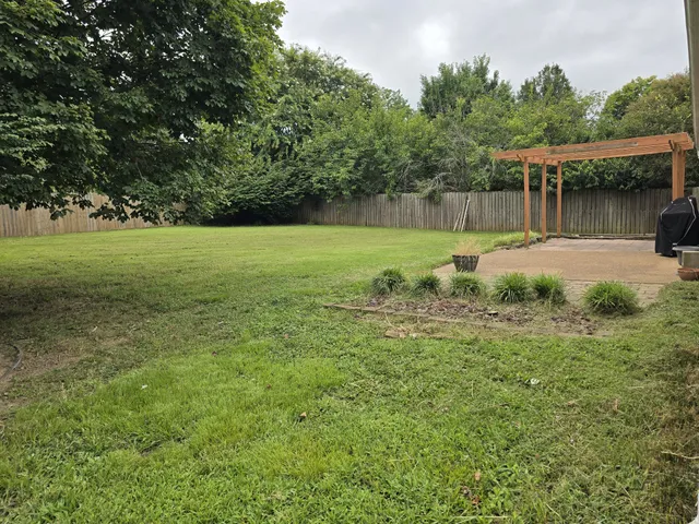 a view of a green field with wooden fence