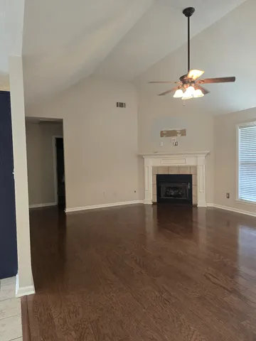 a view of a livingroom with a fireplace a chandelier fan and a fireplace