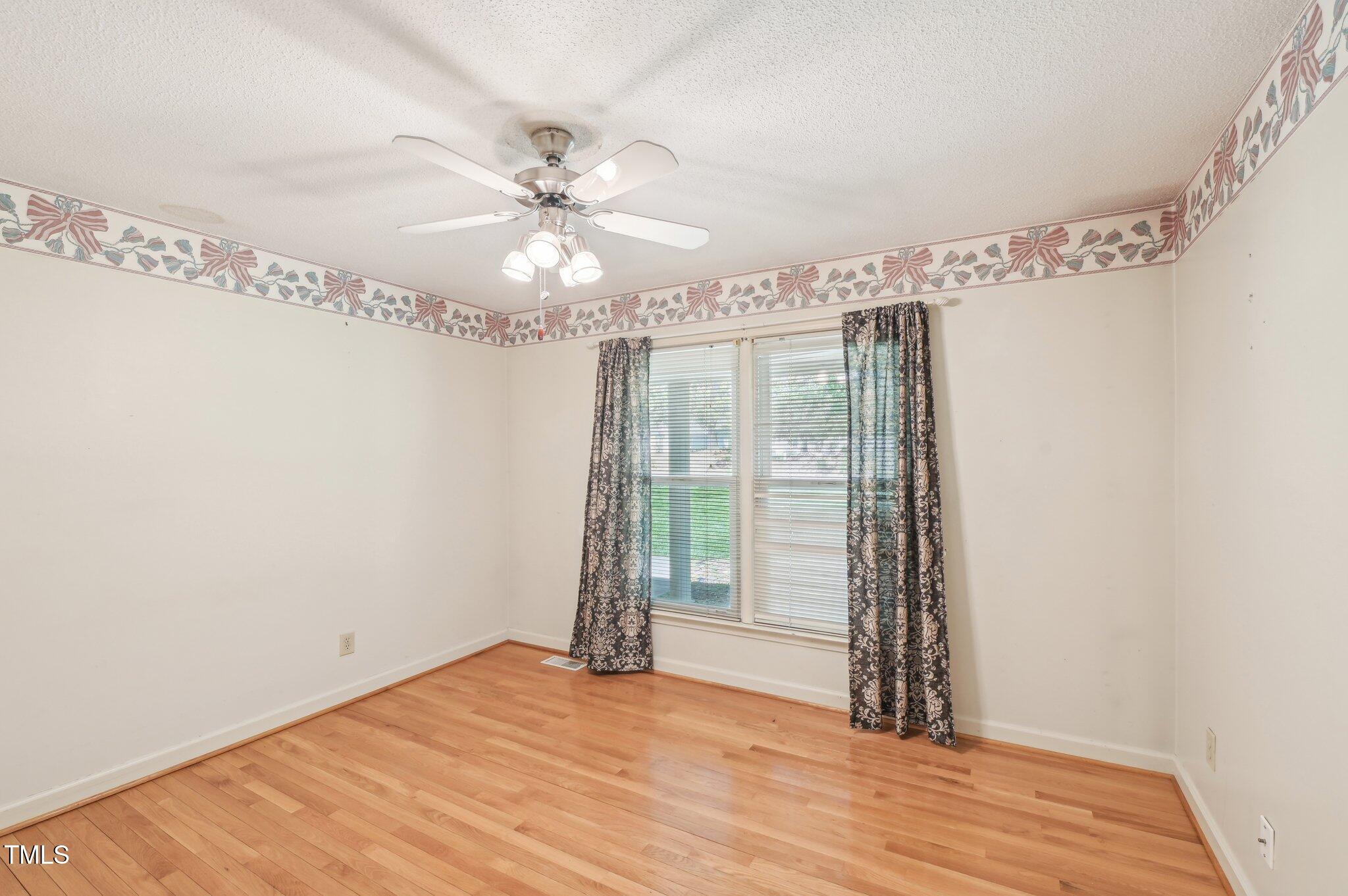 3011 Old Hillsborough Road Mebane, NC 27302 - Photo 22 of 29 a view of an empty room with chandelier fan and wooden floor