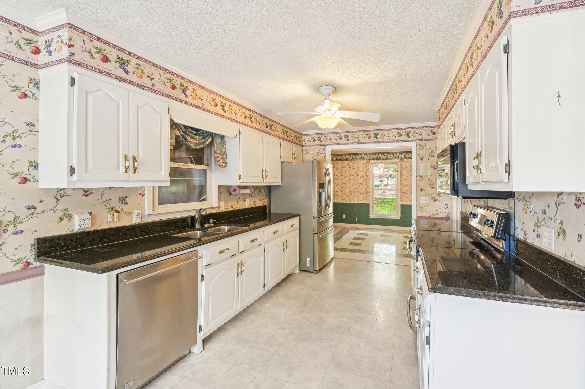 3011 Old Hillsborough Road Mebane, NC 27302 - Photo 10 of 29 a kitchen with stainless steel appliances a sink a stove and white cabinets