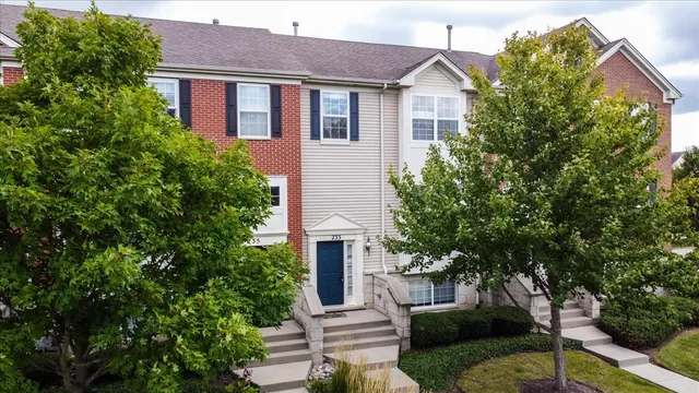 a front view of a house with a yard and trees