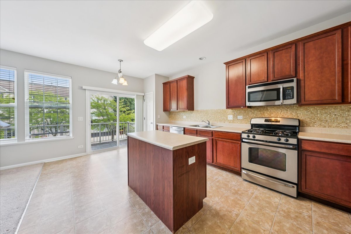 233 Jackson Street Gilberts, IL 60136 - Photo 4 of 29 a kitchen with granite countertop a stove top oven and cabinets