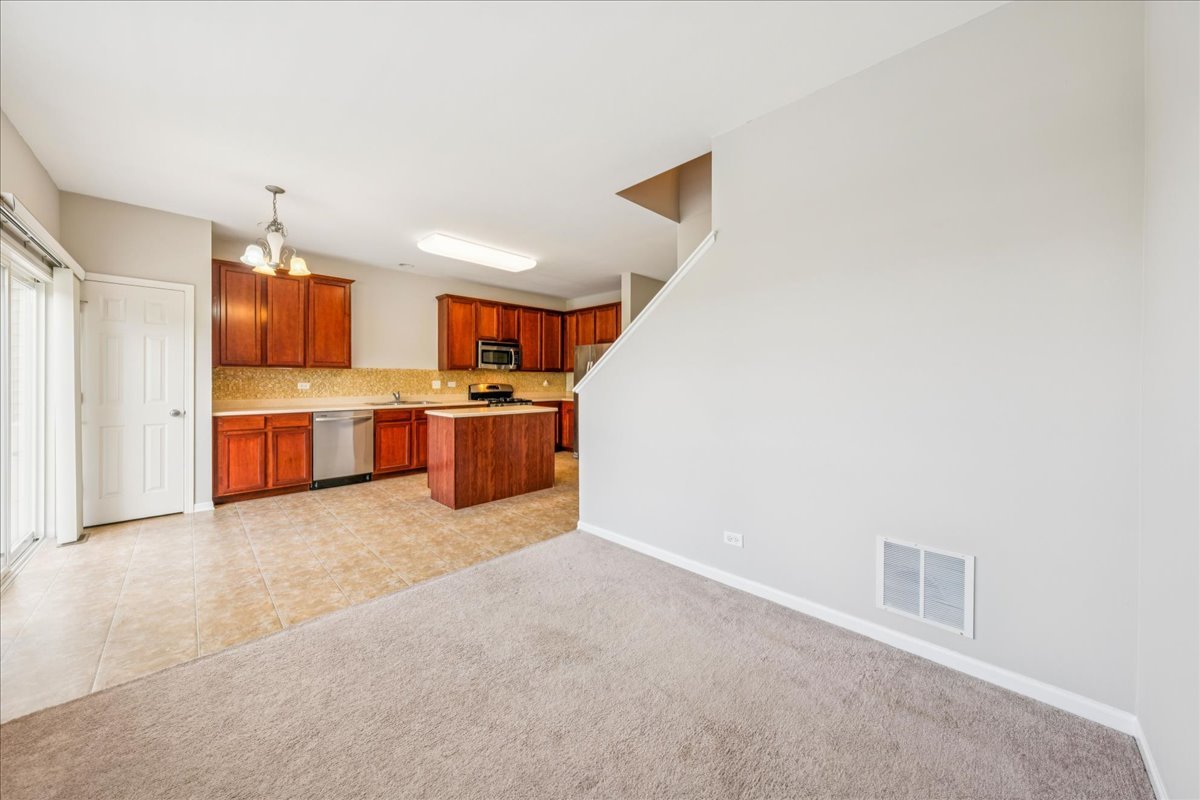 233 Jackson Street Gilberts, IL 60136 - Photo 10 of 29 a large kitchen with stainless steel appliances granite countertop a stove and a refrigerator