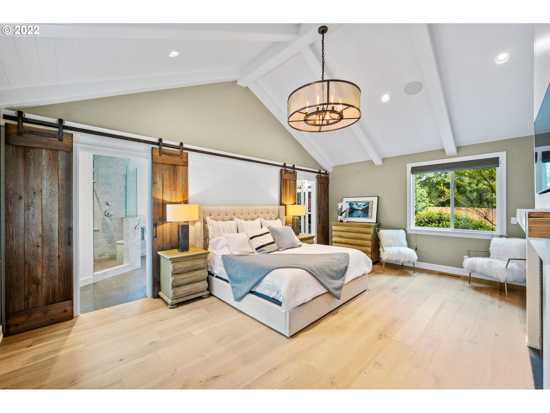 29195 Northeast Benjamin Road Newberg, OR 97132 - Photo 12 of 32 a bedroom with a large bed and a chandelier