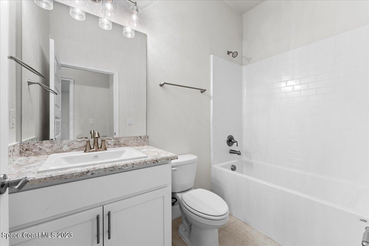 1341 Tupelo Circle Cocoa, FL 32926 - Photo 21 of 27 a bathroom with a granite countertop sink toilet mirror and bathtub