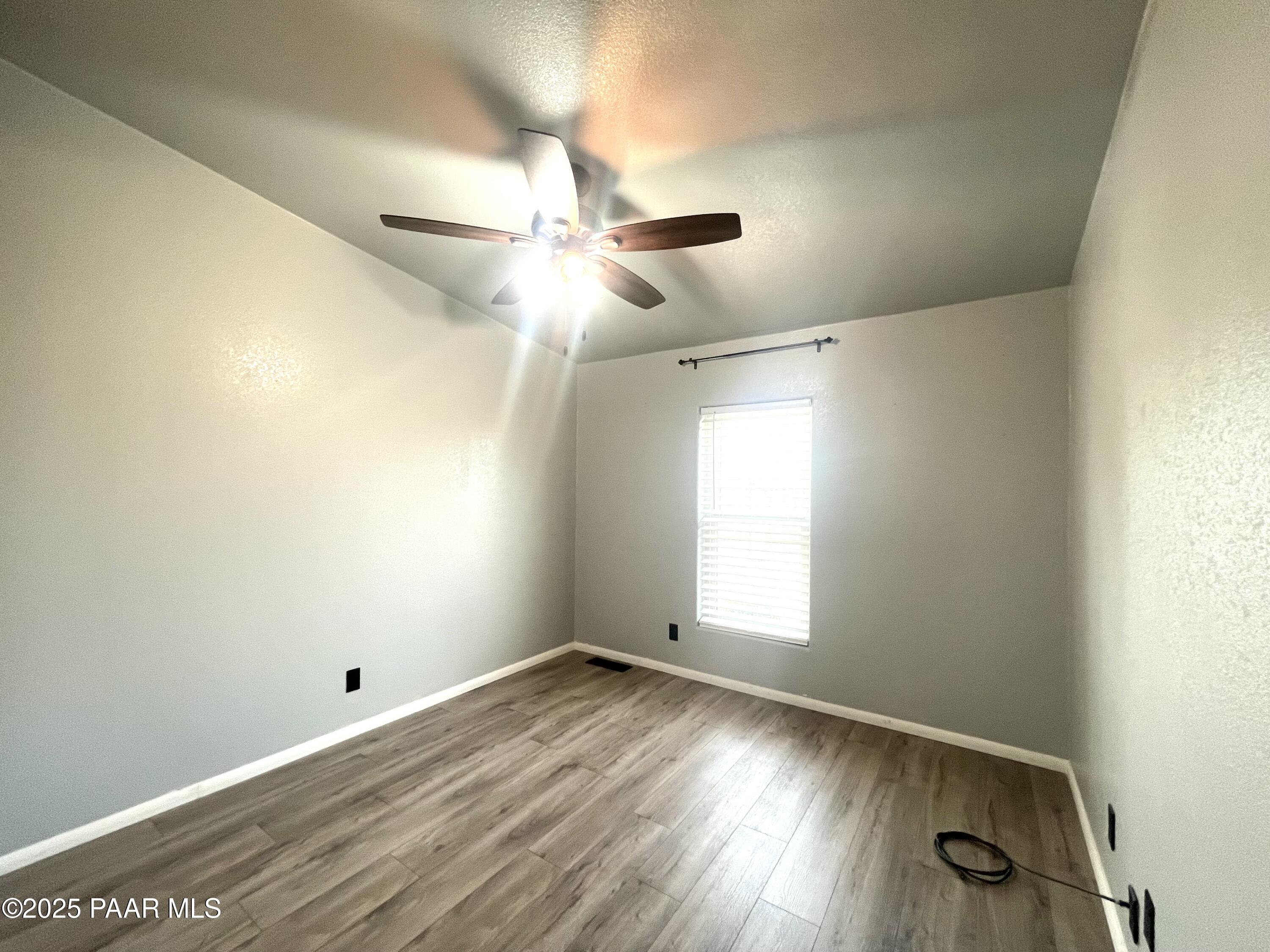 22355 North Docs Road Paulden, AZ 86334 - Photo 11 of 20 a view of empty room with wooden floor and fan