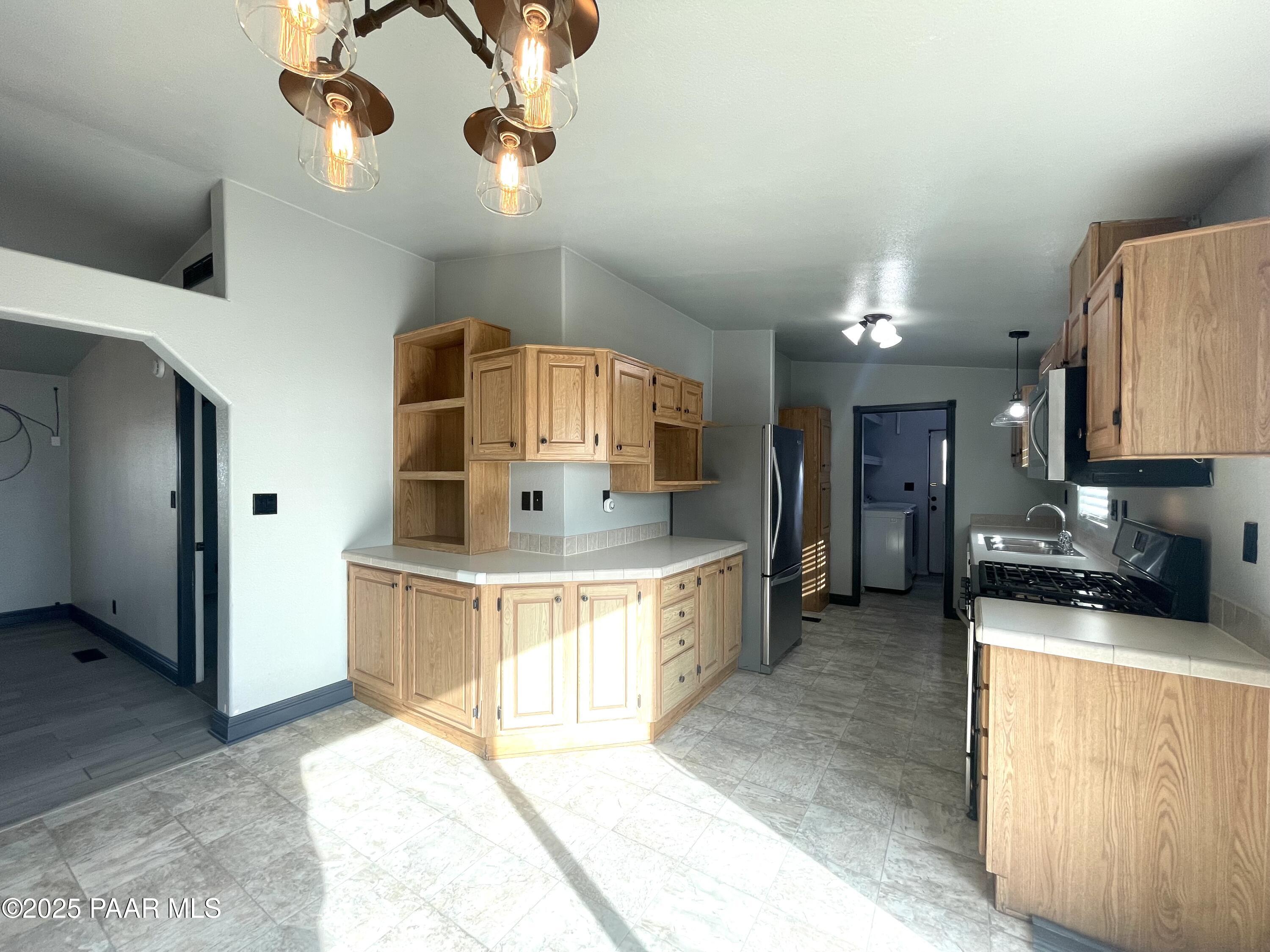 22355 North Docs Road Paulden, AZ 86334 - Photo 5 of 20 a large kitchen with stainless steel appliances a stove a sink cabinets and a wooden floor