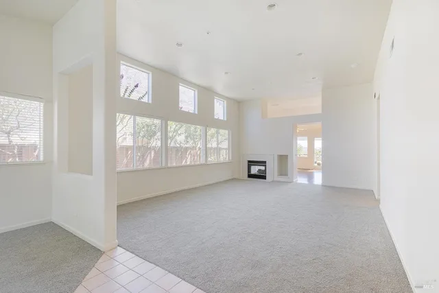 a living room with stainless steel appliances kitchen island hardwood floor and a large window
