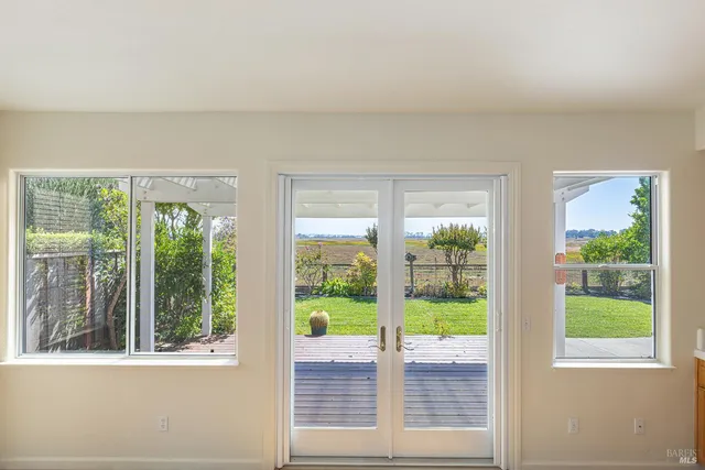 a view of a backyard with lawn chairs under an umbrella