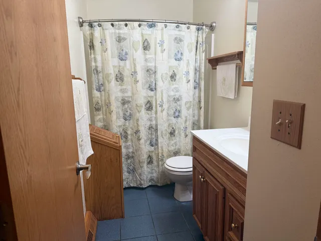 a bathroom with a granite countertop toilet and a shower