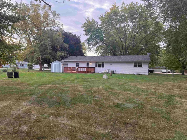 a view of a house with a big yard and large trees