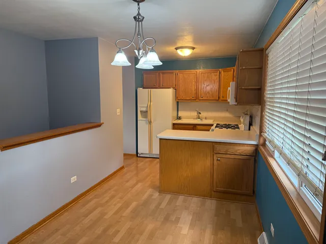 a kitchen with kitchen island white cabinets and refrigerator