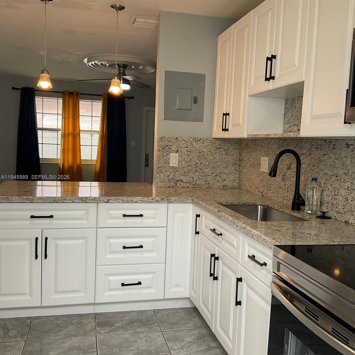 337 Phippen Waiters Road, Unit 12 Dania Beach, FL 33004 - Photo 2 of 9 a kitchen with cabinets appliances a sink and a counter top space