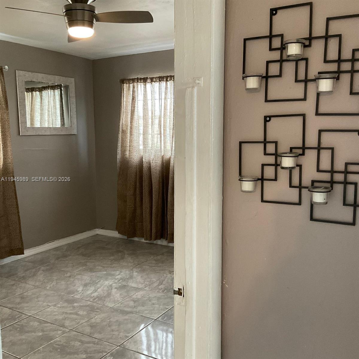 337 Phippen Waiters Road, Unit 12 Dania Beach, FL 33004 - Photo 7 of 9 an empty room with windows and ceiling fan