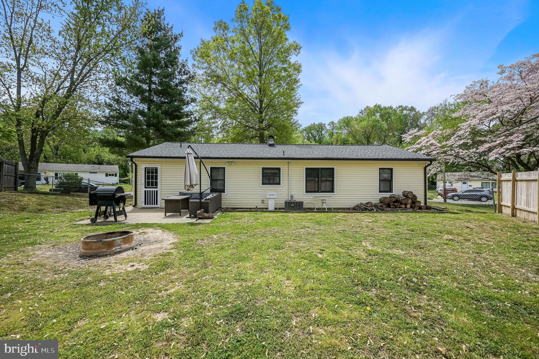 87 Wayne Drive Dover, DE 19901 - Photo 5 of 20 a backyard of a house with table and chairs under an umbrella