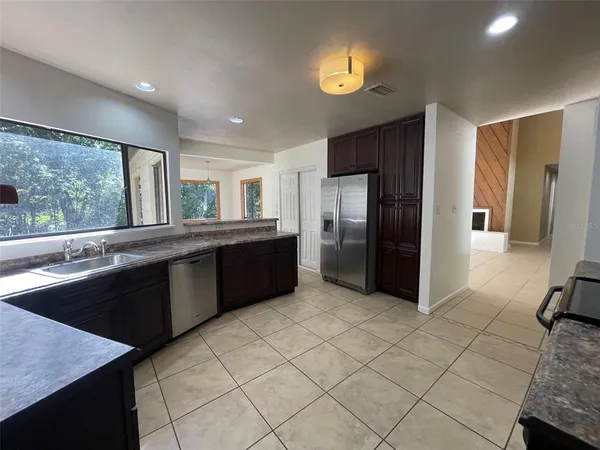 a large kitchen with a window and stainless steel appliances